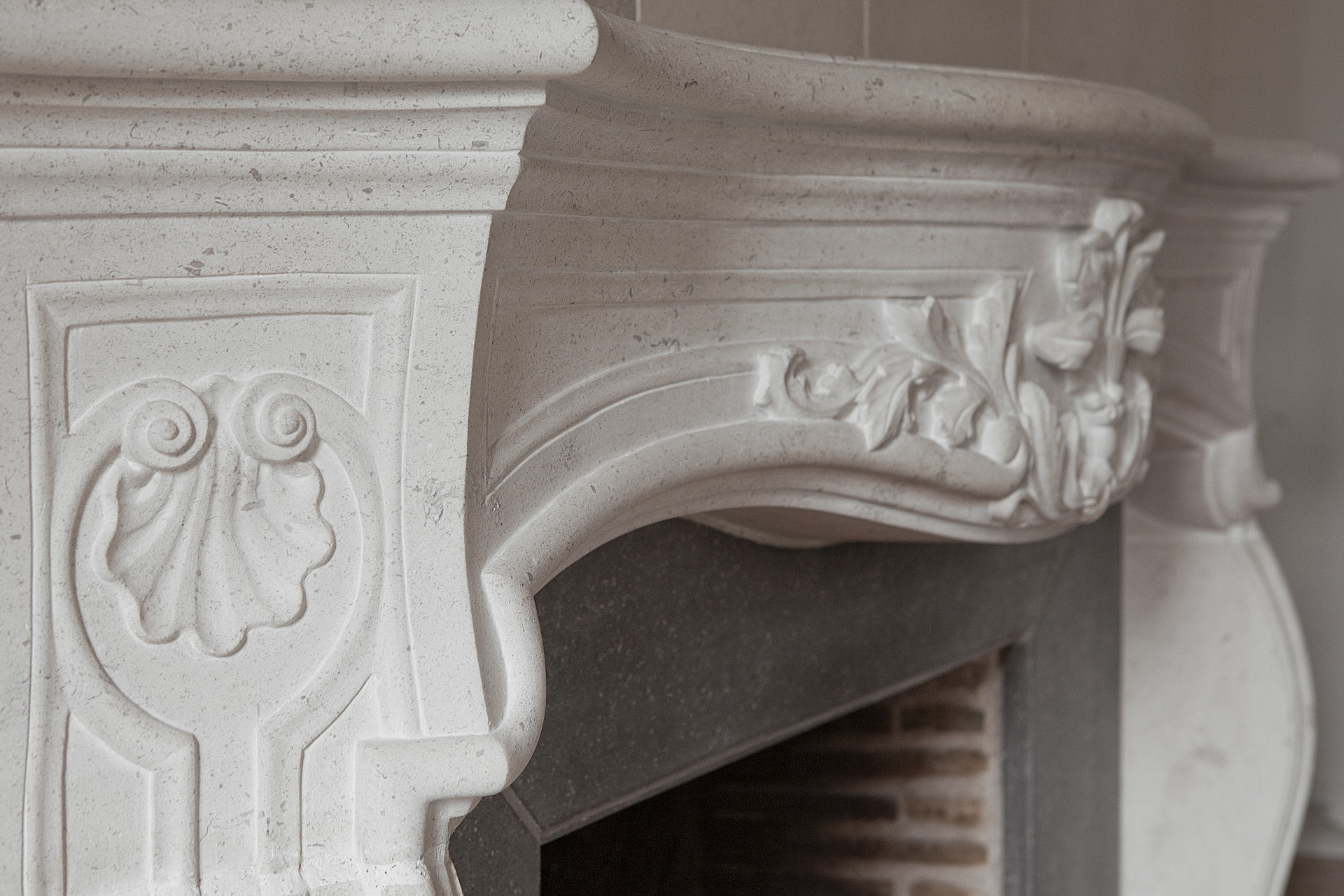Vue des courbes et ornements du linteau de cette cheminée Louis XV